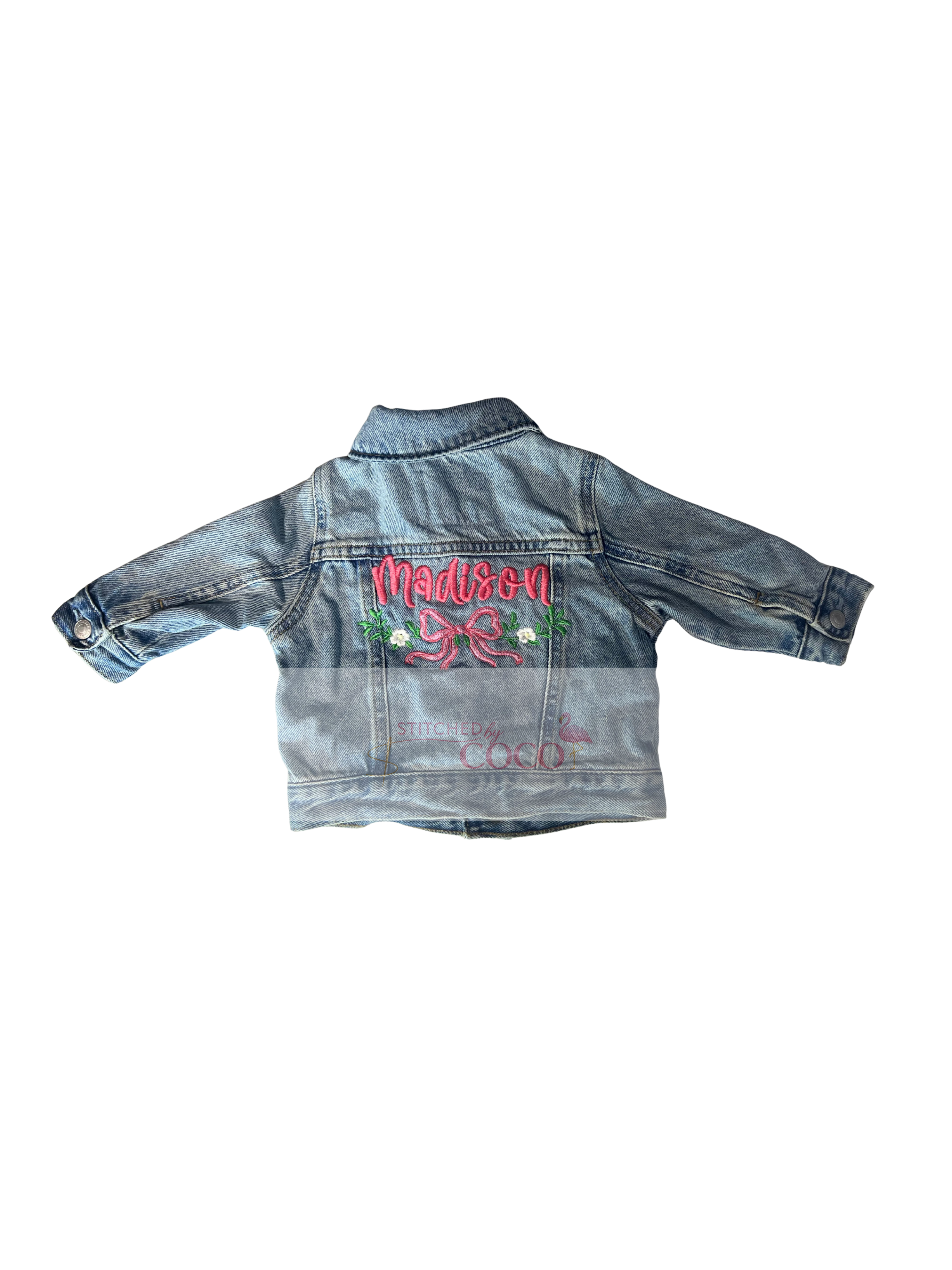 Light denim jacket featuring a custom embroidered name with stitched bow and flowers on the back