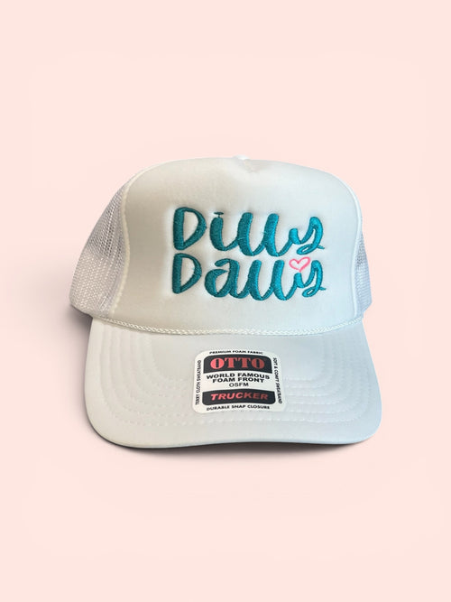 White OTTO foam‑front trucker hat with teal embroidered “Dilly Dally” text and a small pink heart on the front panel.